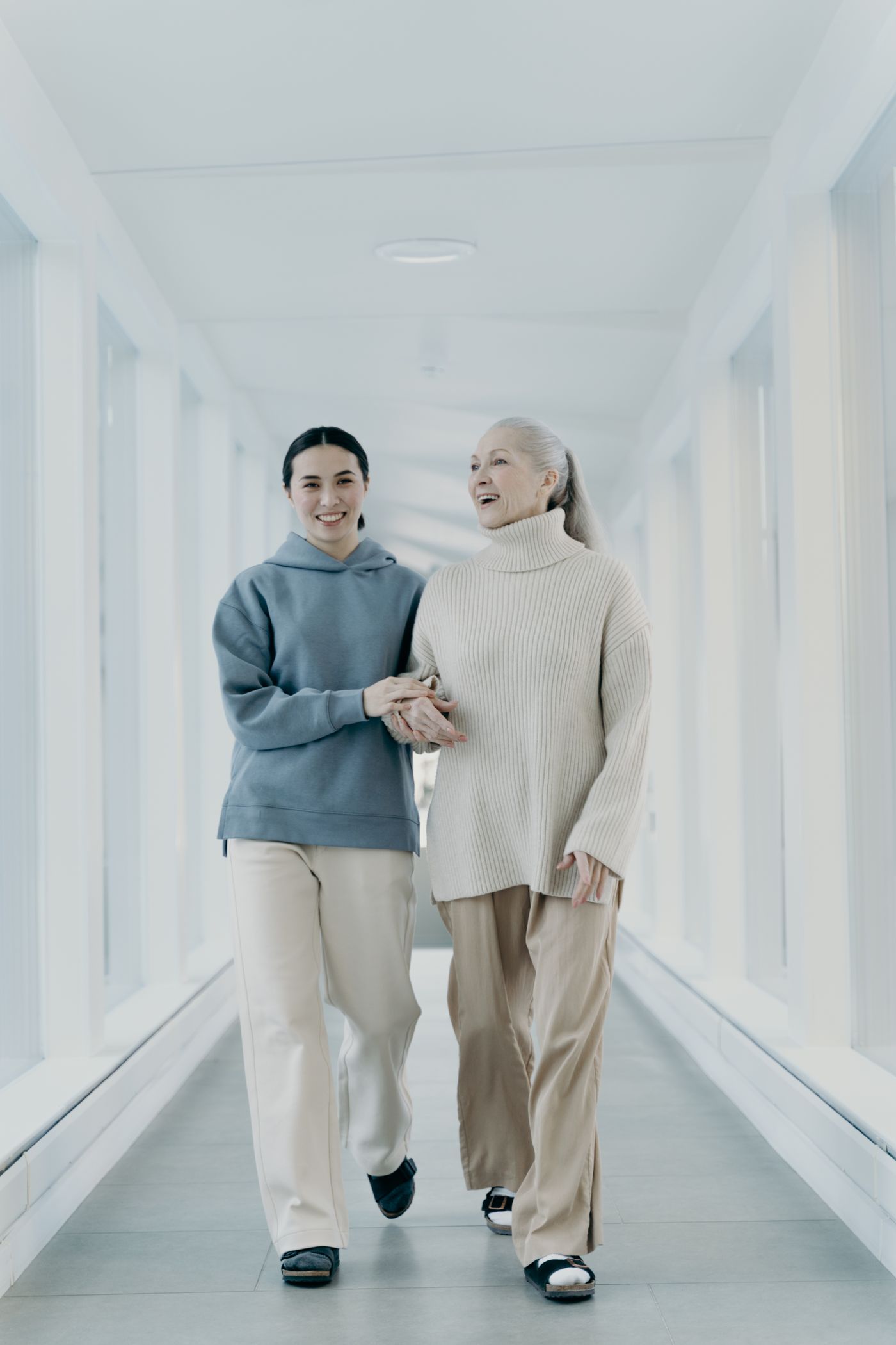 A support worker and senior client walking together, smiling